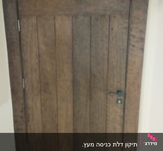 דלת עץ חומה עם ידית מתכת שחורה